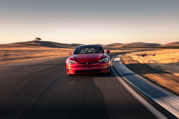 El Model S rojo tomando una curva, realzando su perfil deportivo y su enganche con la carretera. El Model S rojo tomando una curva, realzando su perfil deportivo y su enganche con la carretera.