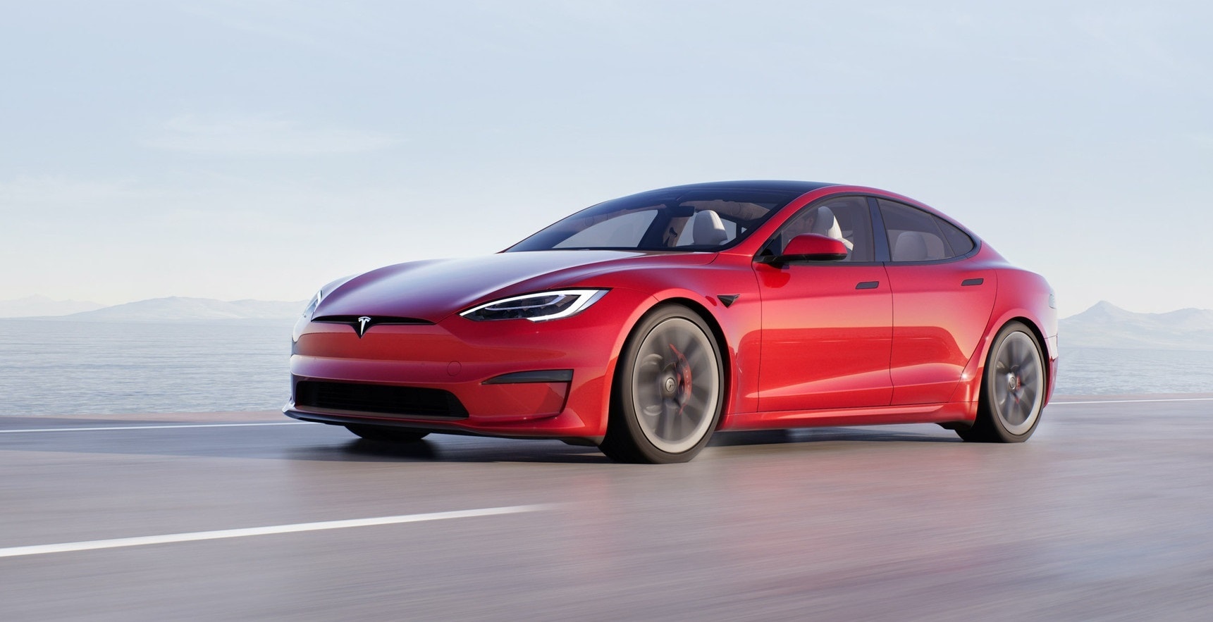 Vista lateral del Tesla Model S en movimiento, destacando su diseño aerodinámico.