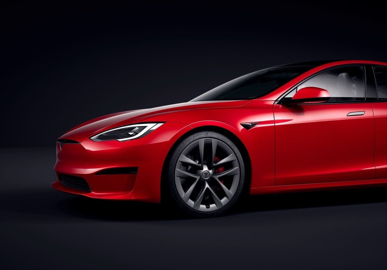 Perfil elegante de un Tesla Model S en color rojo, enfatizando su diseño aerodinámico.