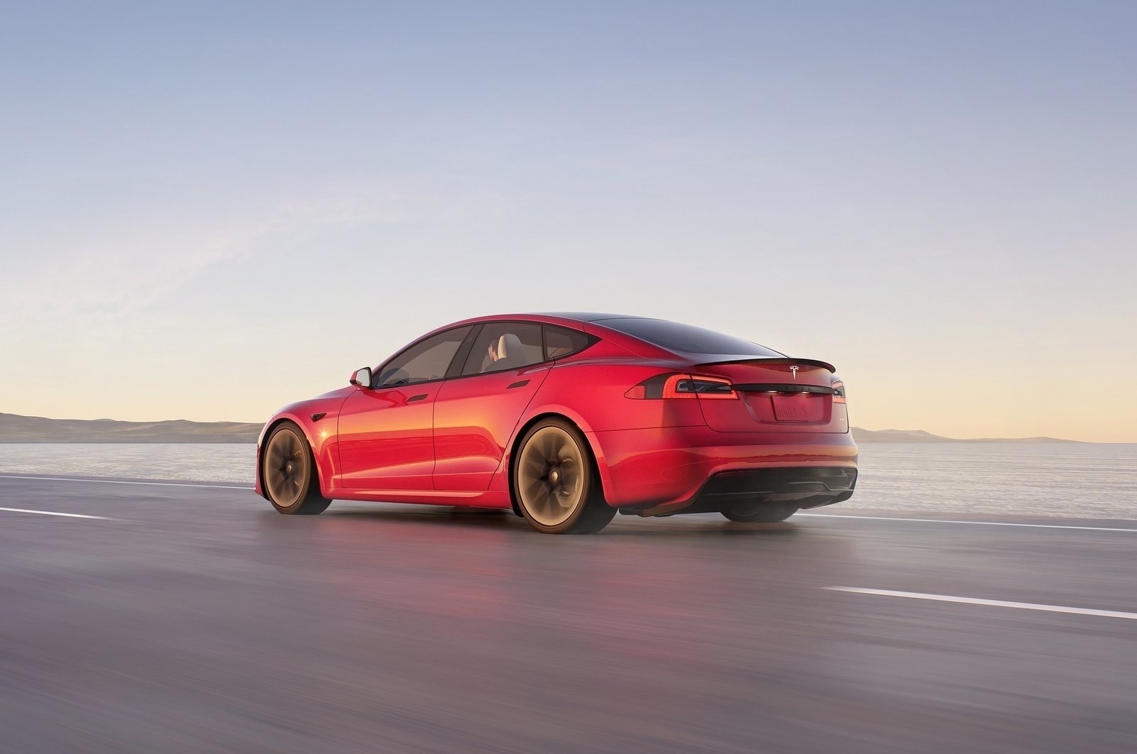 Perspectiva de la parte trasera del Tesla Model S rojo, mostrando su distintiva línea de luces.