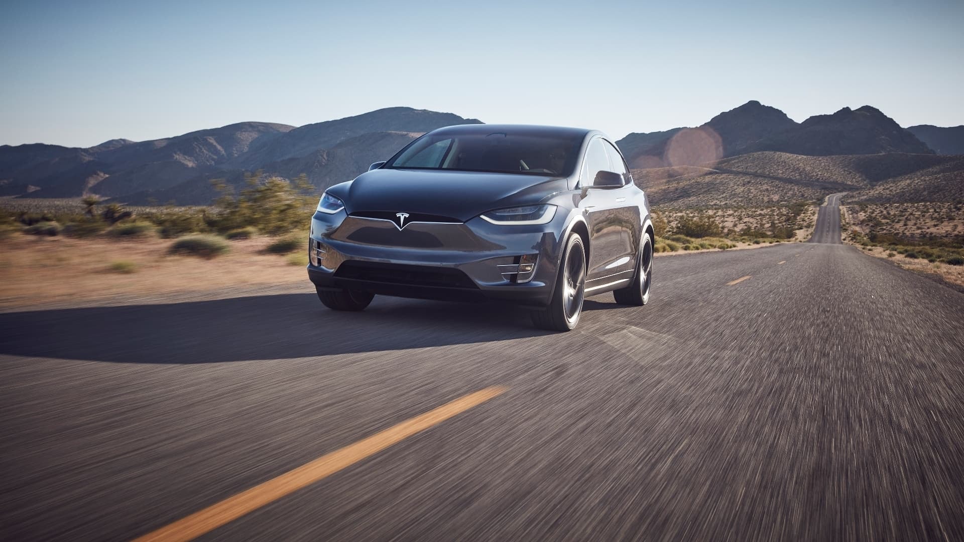 El Tesla Model X en movimiento mostrando su perfil frontal y lateral.