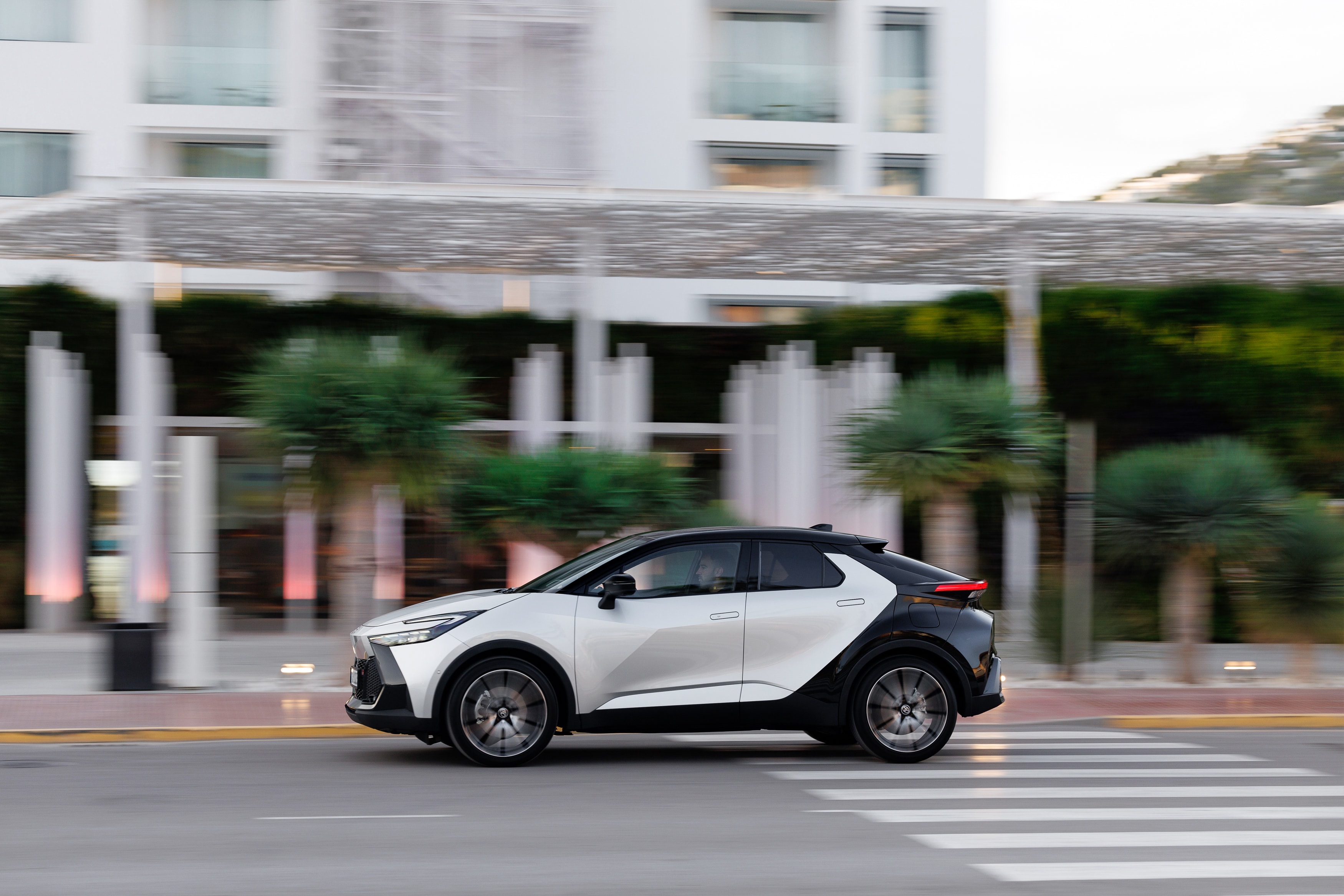 El Toyota C-HR híbrido en un cruce, mostrando su perfil lateral en el ámbito urbano.