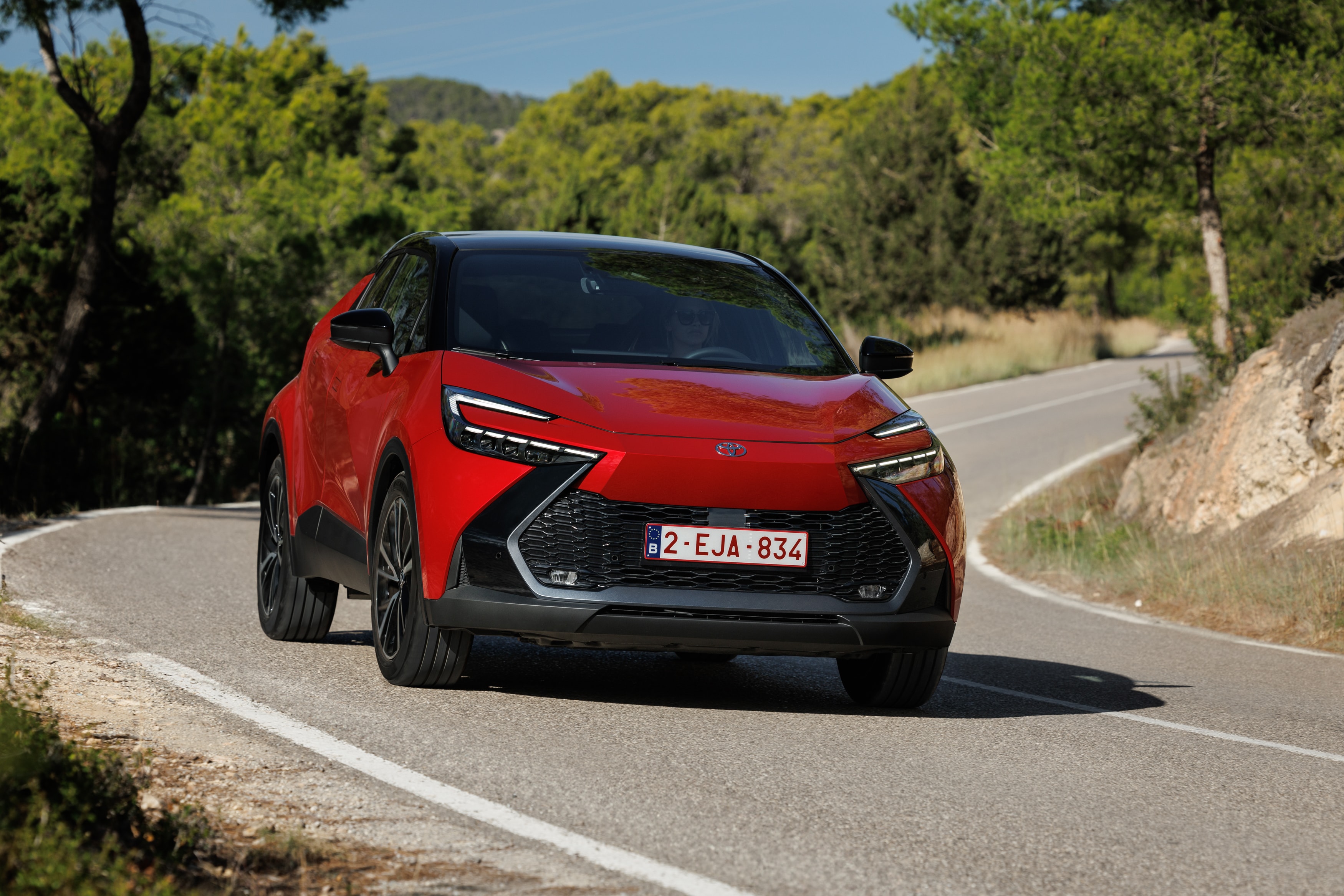 Toyota C-HR híbrido visto desde atrás en carretera.