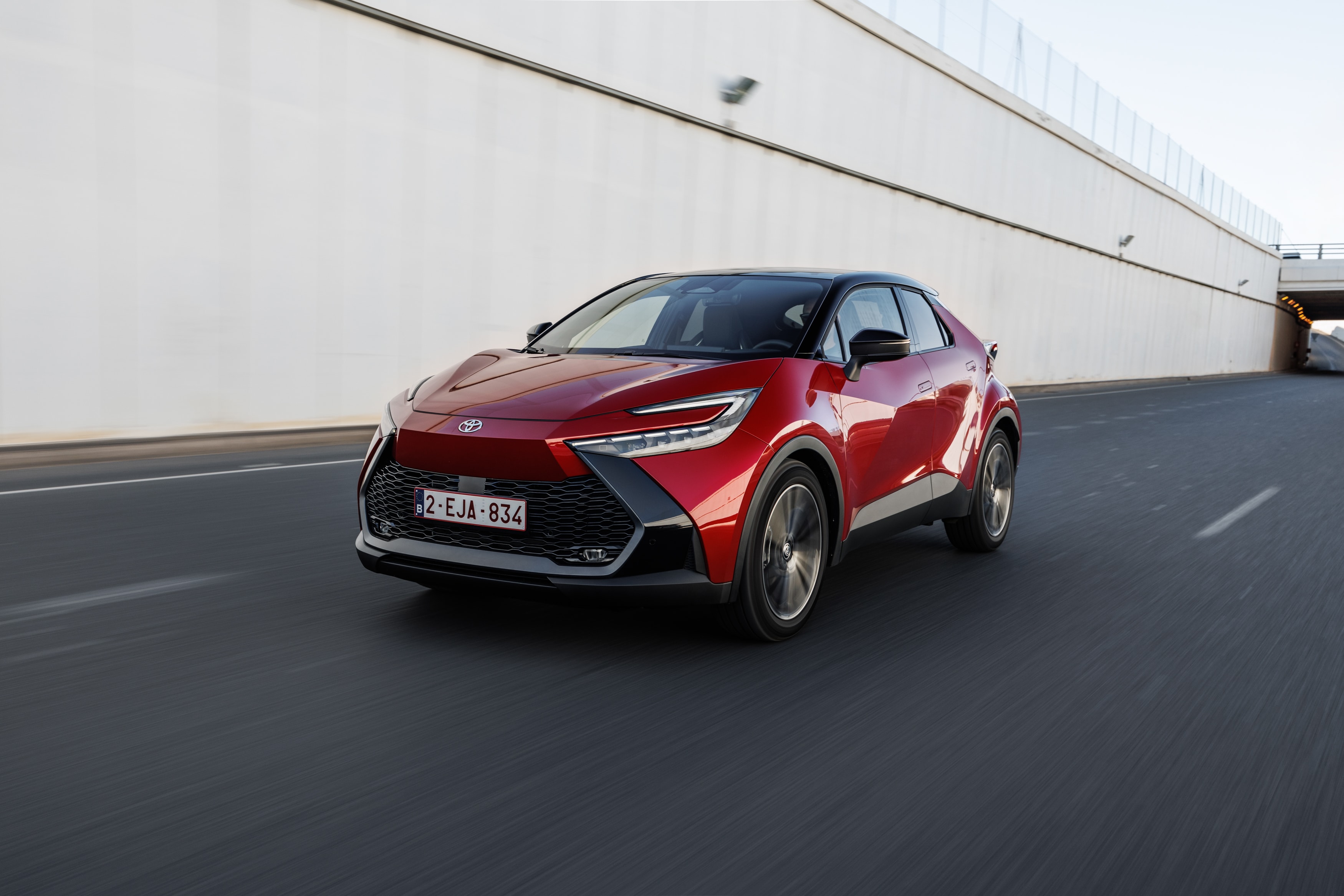Lateral en movimiento del Toyota C-HR híbrido, diseño fluido y deportivo.