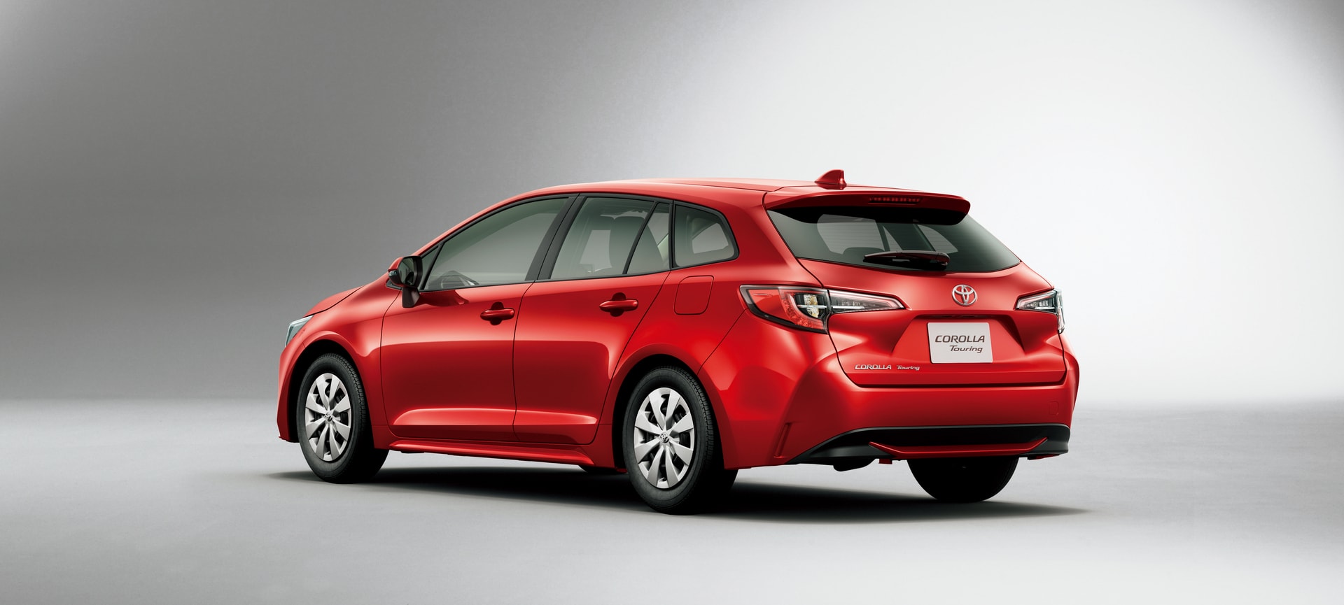 Vista trasera y lateral que enfatiza el dinamismo del Toyota Corolla Touring en rojo.