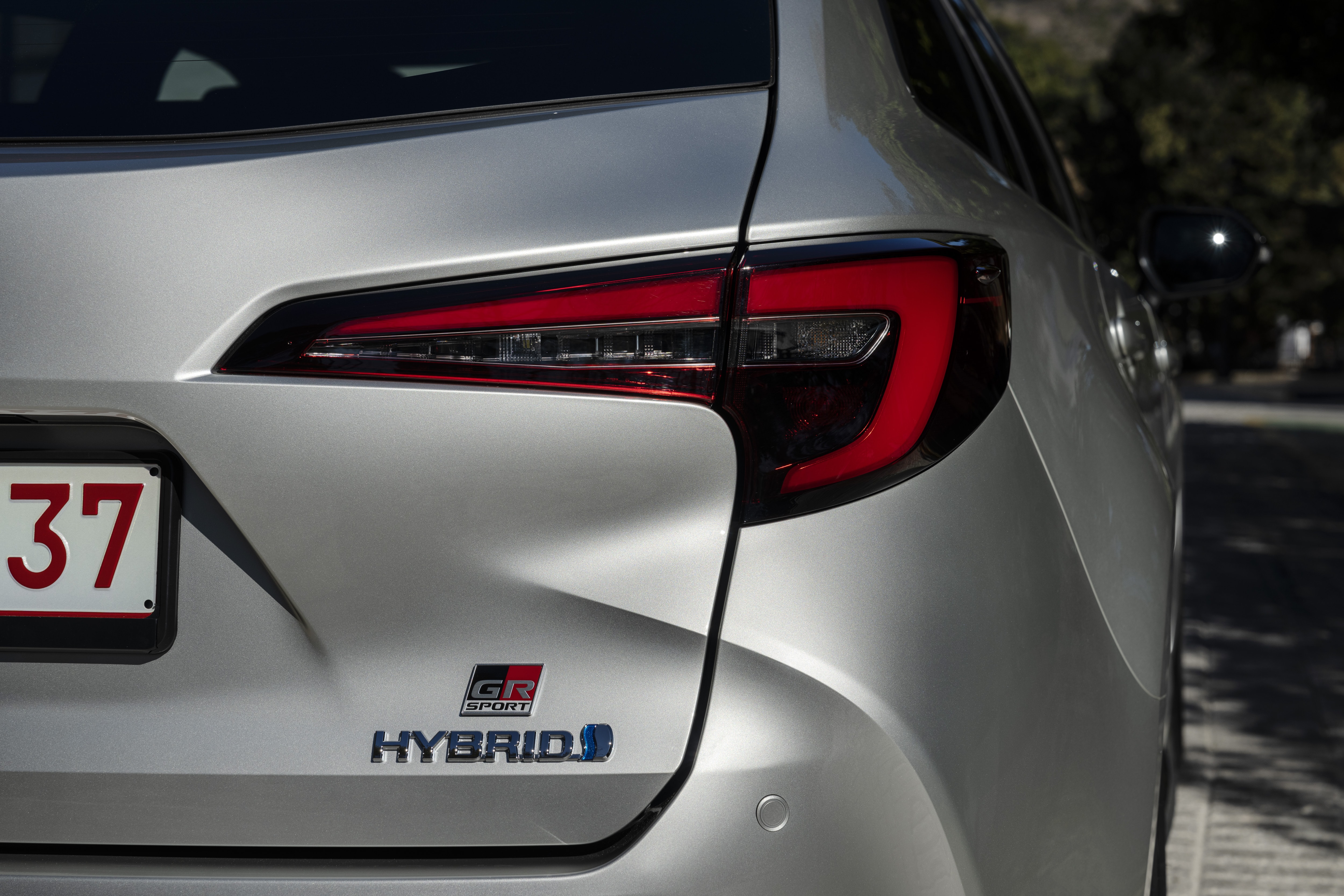 Detalle trasero mostrando el emblema híbrido del vehículo.