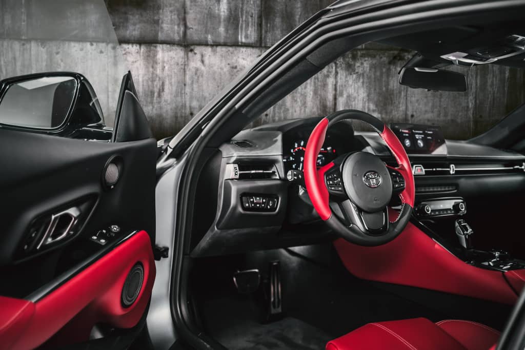 Cabin interior highlighting the red sports seats and dashboard.