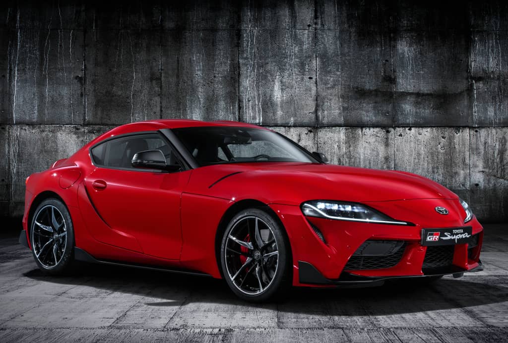 Perfil del Toyota GR Supra en rojo, exhibiendo líneas que reflejan su naturaleza deportiva.