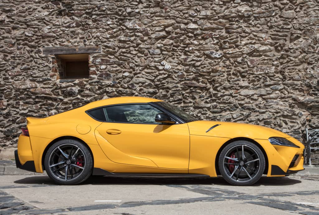 Perfil lateral del Toyota GR Supra, destacando su dinámica línea en amarillo.