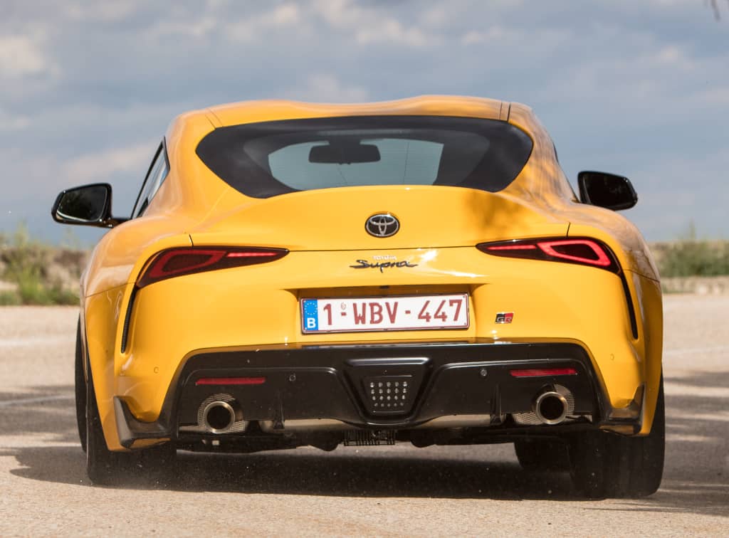 Vista trasera del Toyota GR Supra amarillo, mostrando su diseño deportivo y difusor.