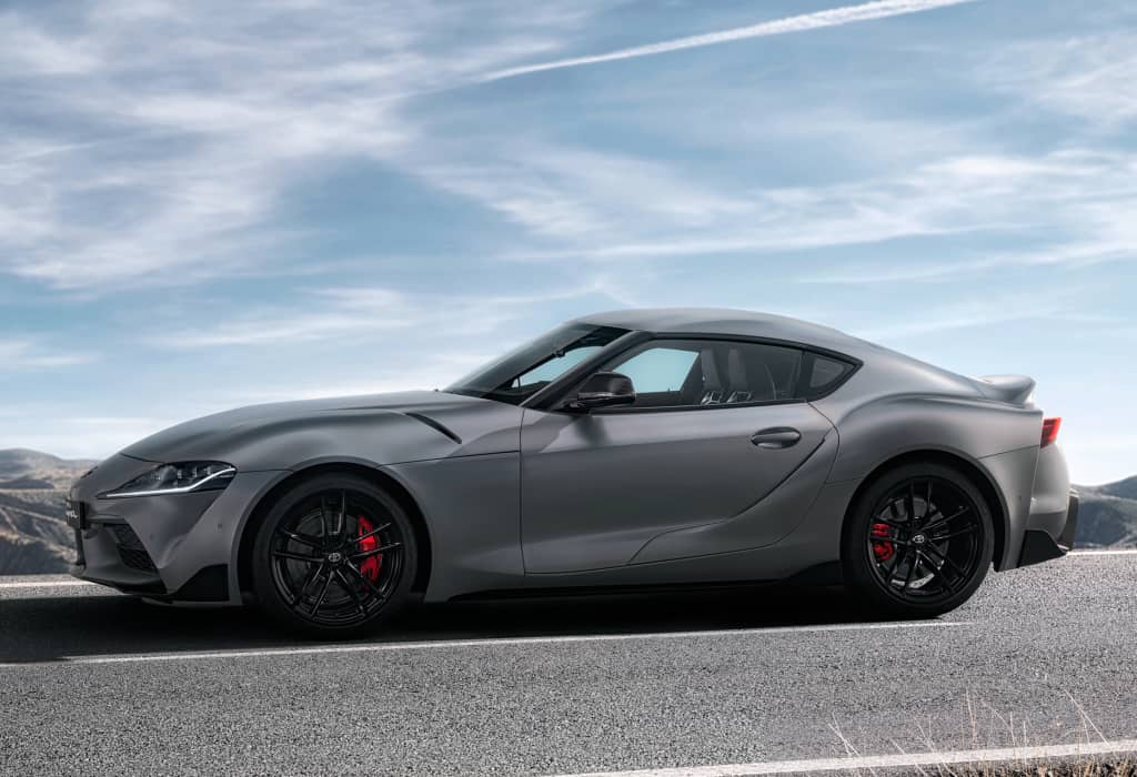 Perfil lateral del Toyota GR Supra en color gris, mostrando su línea deportiva.