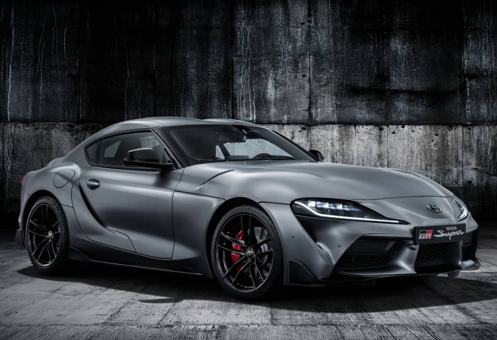 Vista lateral del Toyota GR Supra en gris, mostrando su silueta aerodinámica.