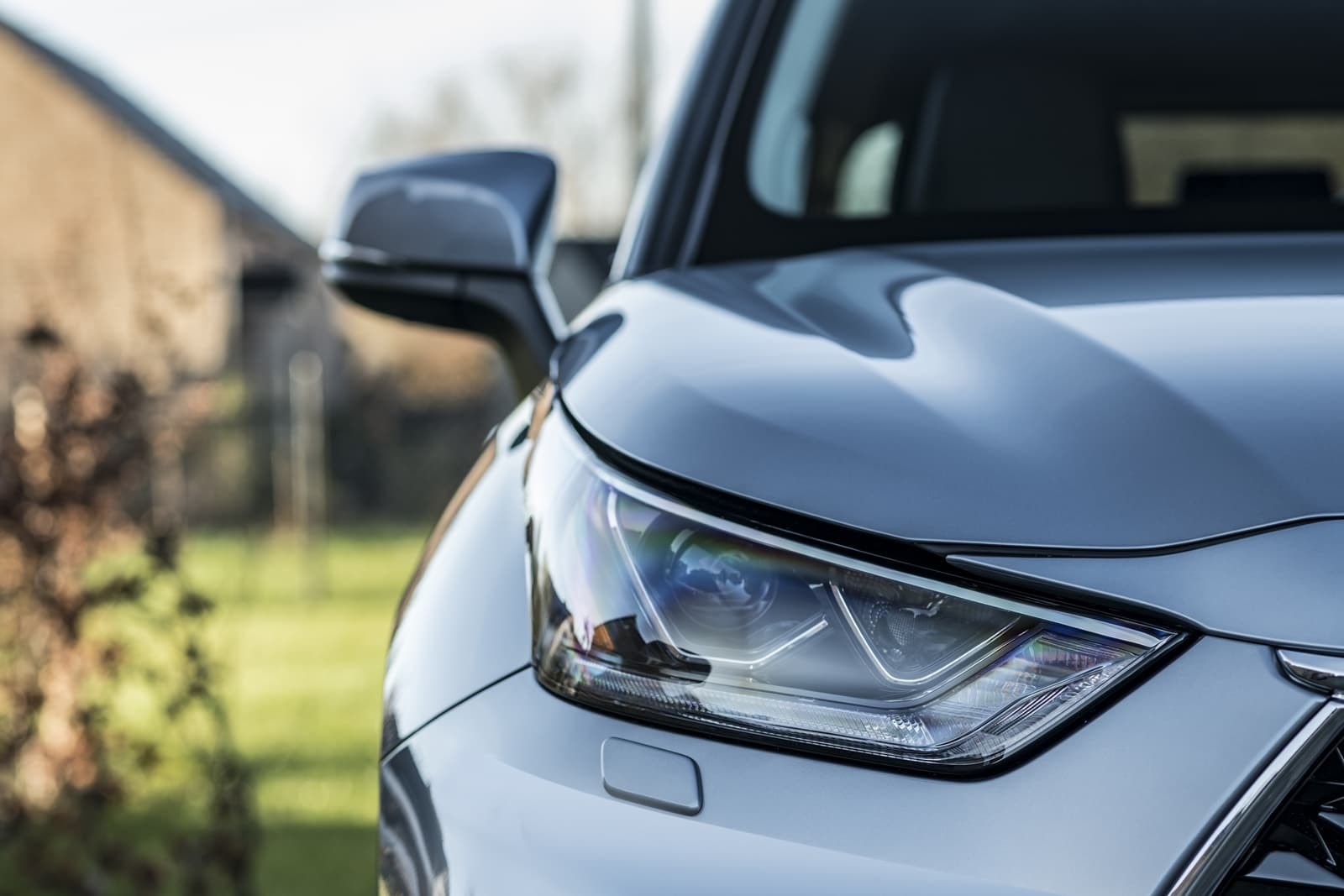 Detalle del faro y espejo retrovisor del Highlander, diseño elegante y moderno.