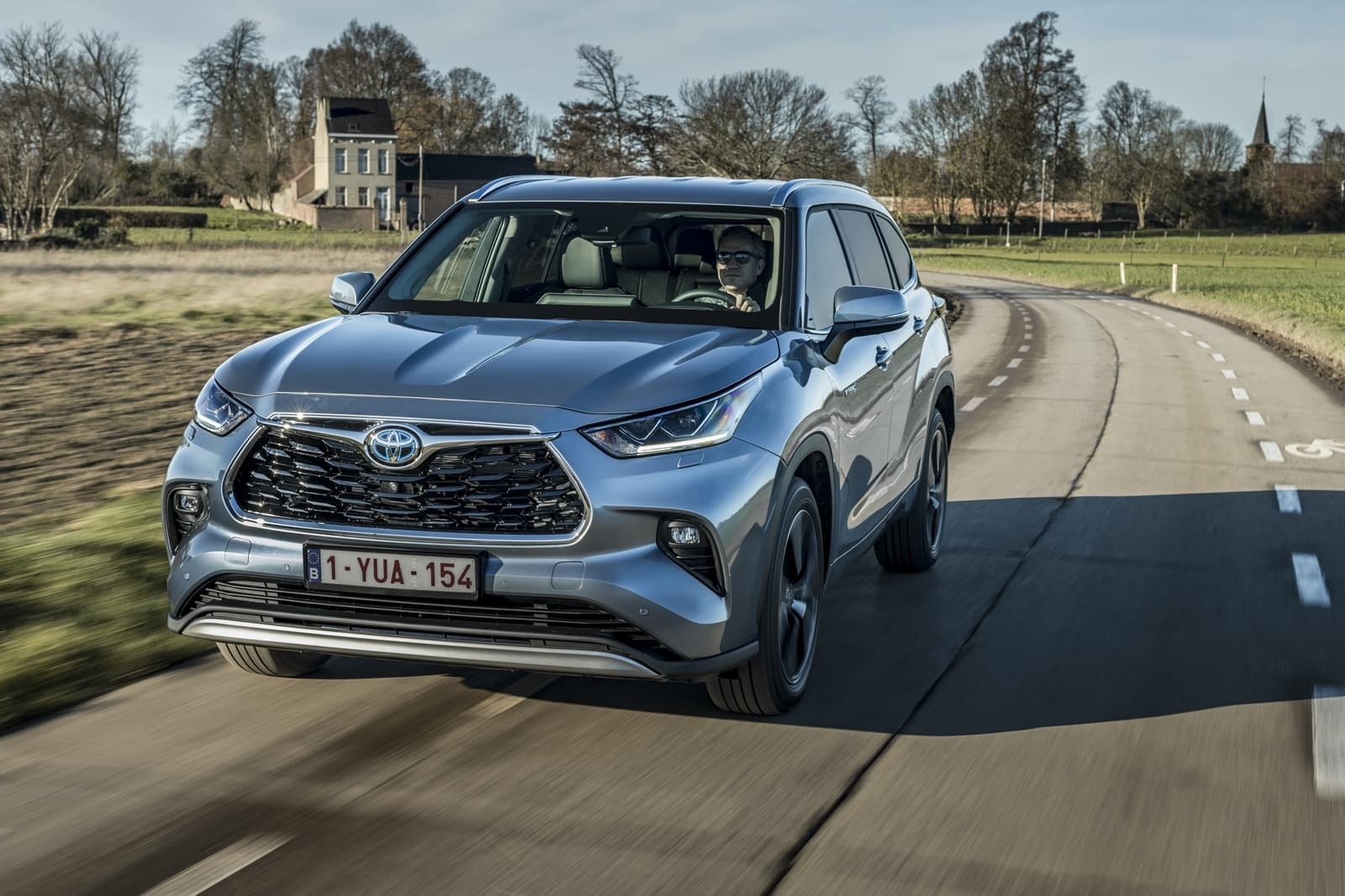 Frente del Toyota Highlander Híbrido bajo una hermosa luz solar, destacando su diseño frontal.