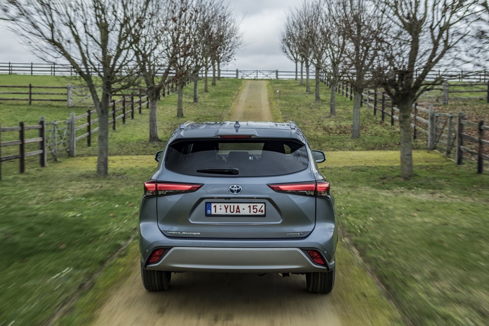 Vista posterior del Toyota Highlander híbrido en un entorno campestre.