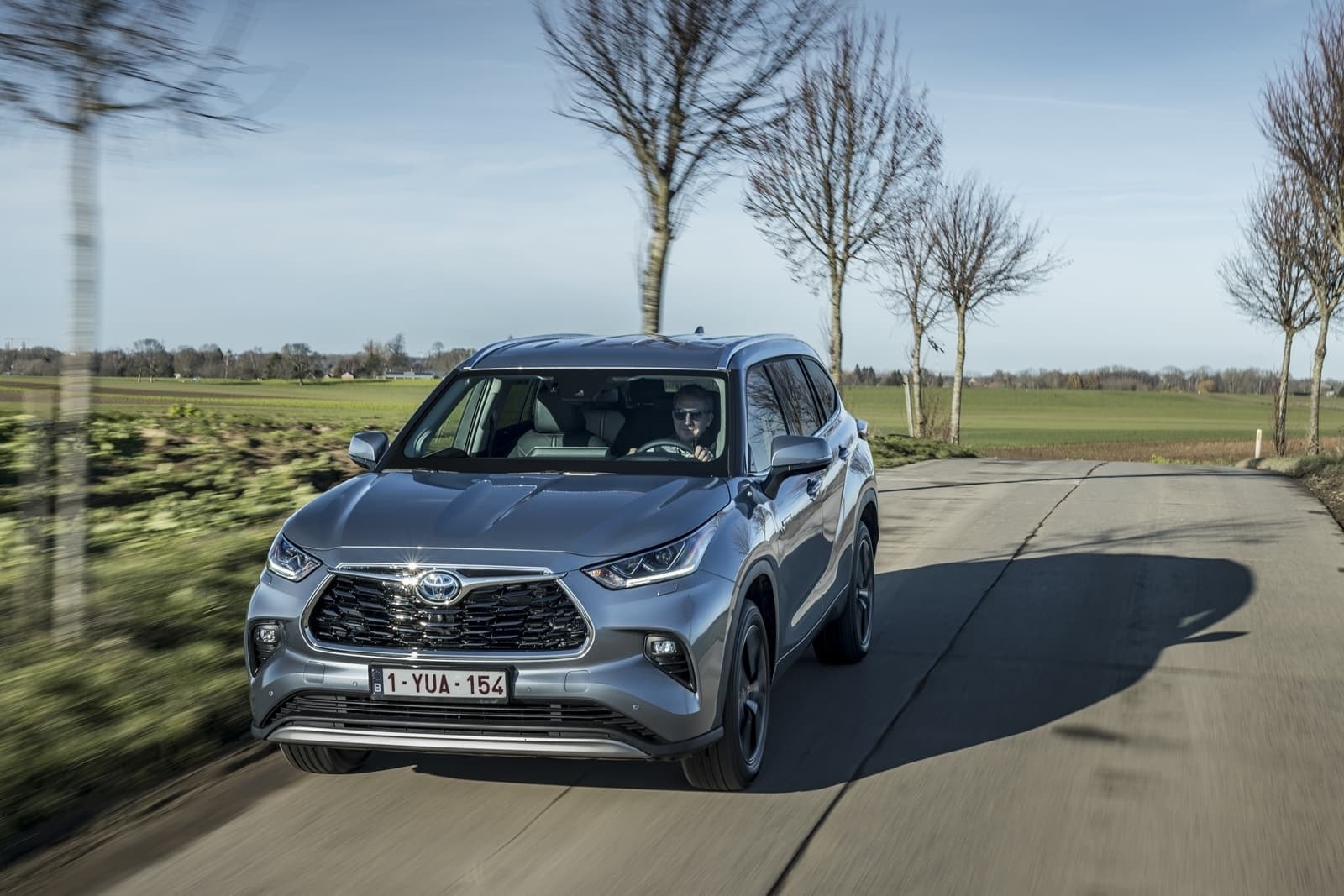 Toyota Highlander Híbrido capturado desde un ángulo delantero lateral en movimiento.