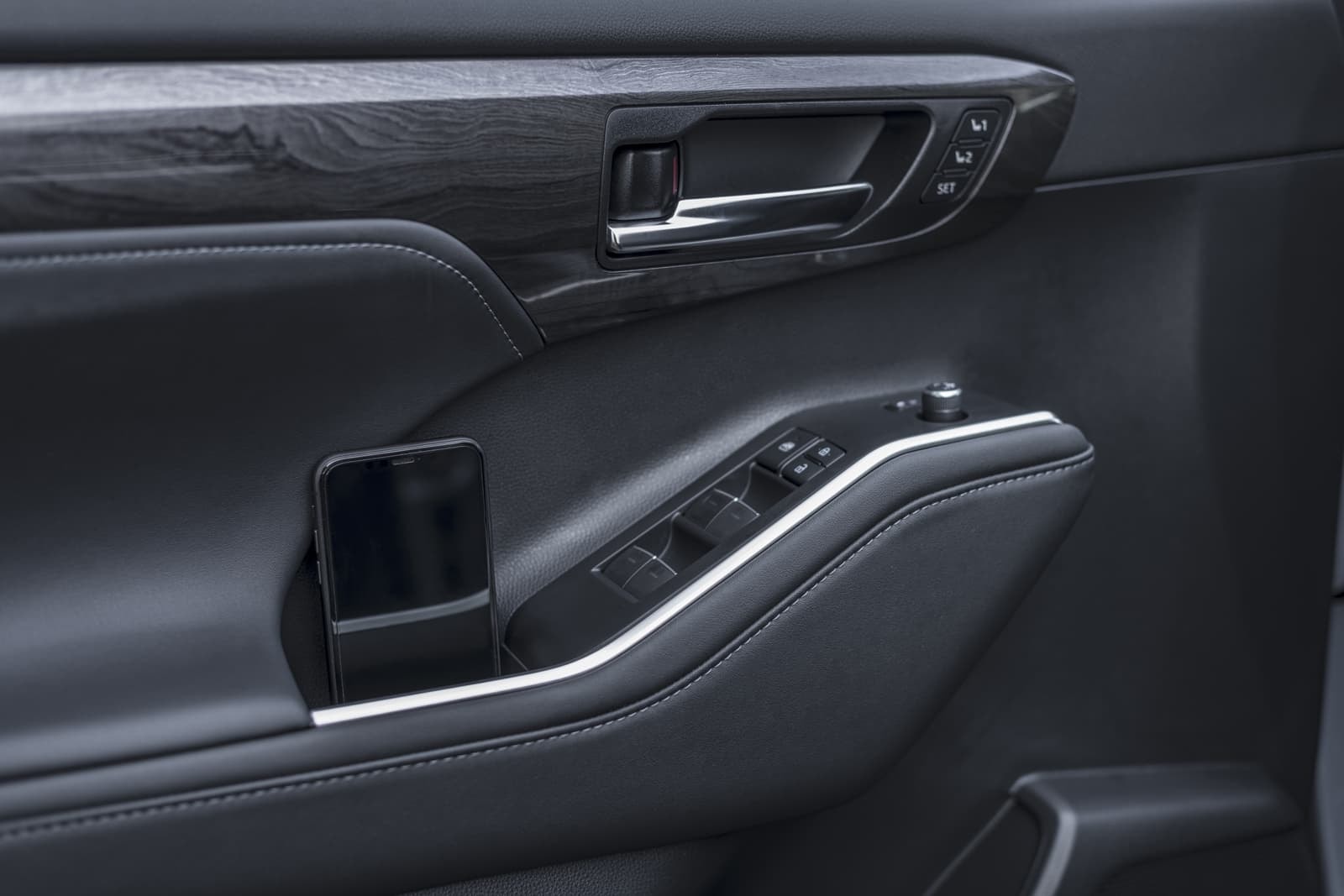 Control de ventanas y ajustes de espejos en puerta del conductor.