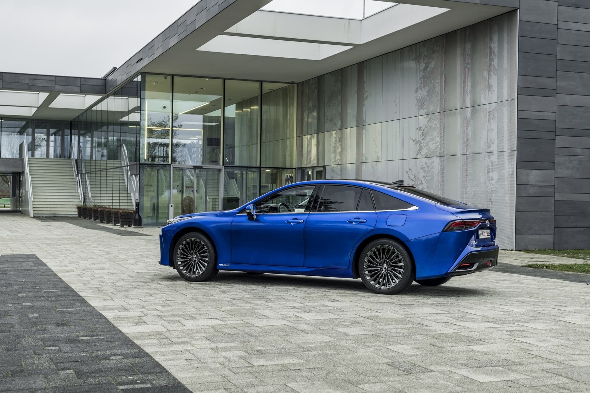 Toyota Mirai estacionado frente a arquitectura contemporánea.