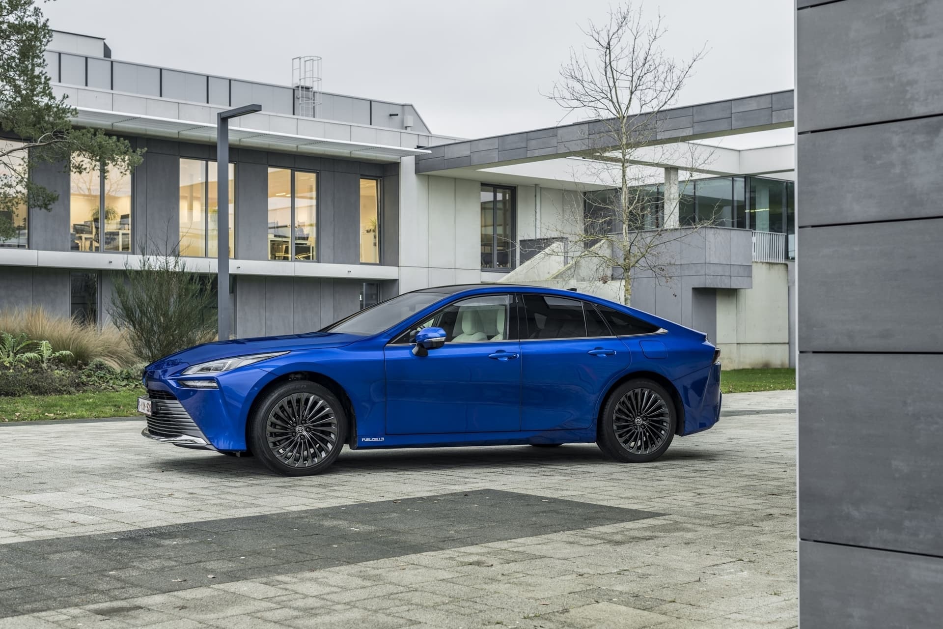 Toyota Mirai perfilado en un contexto urbano moderno, estilo sofisticado.