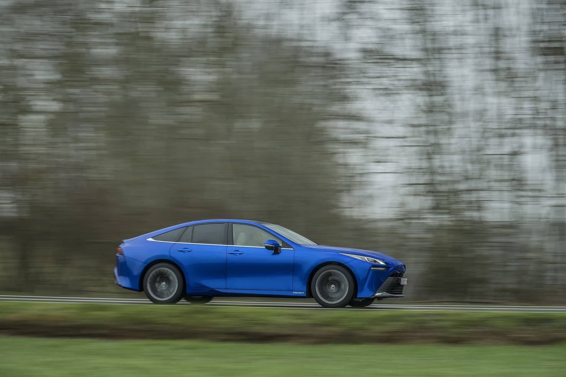 Vista dinámica lateral del Toyota Mirai en movimiento.