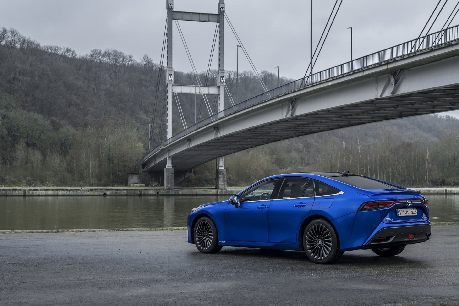 El Mirai mostrando su diseño aerodinámico con un puente icónico de fondo.