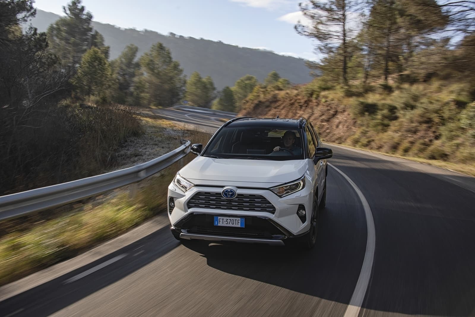 Vista frontal del RAV4 híbrido en conducción, enfatizando su robusto diseño y tecnología.
