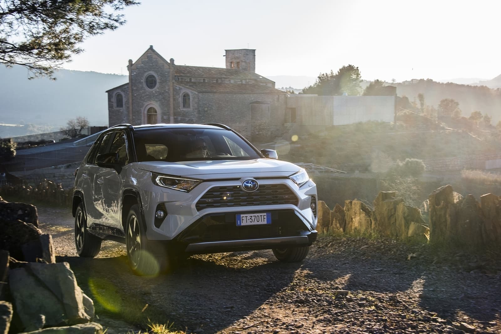 RAV4 híbrido en escenario rústico al amanecer, enfoque frontal