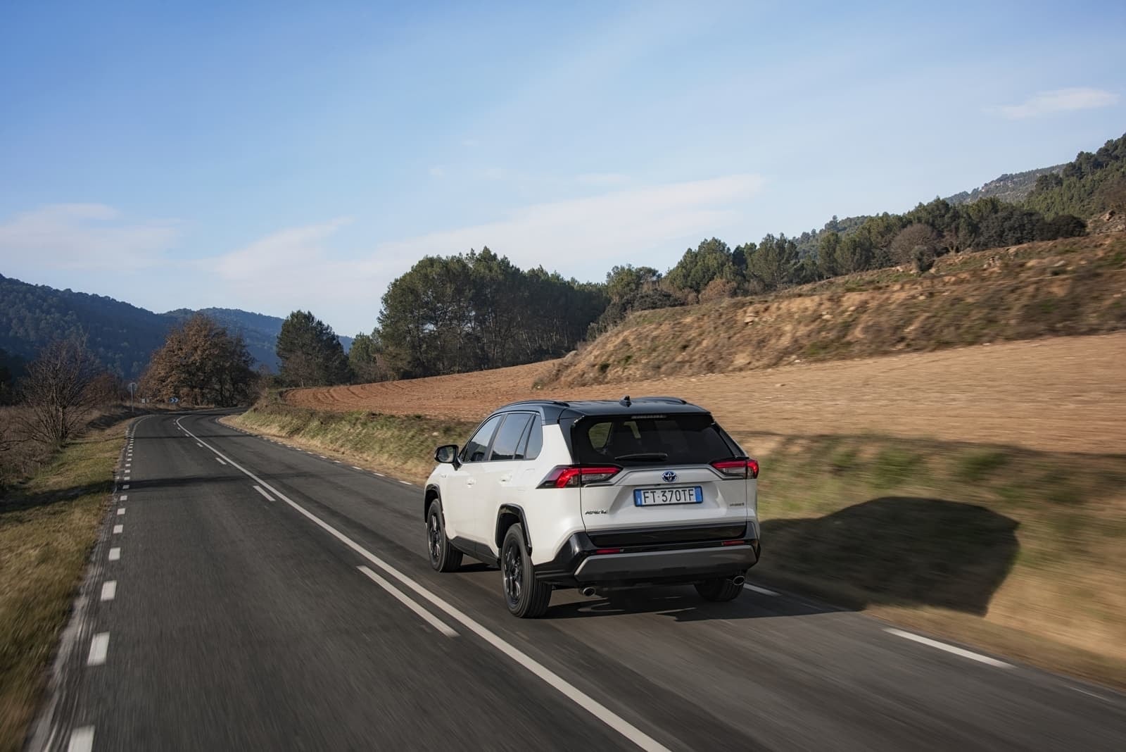 Vista trasera del RAV4 Híbrido destacando su diseño y carretera.