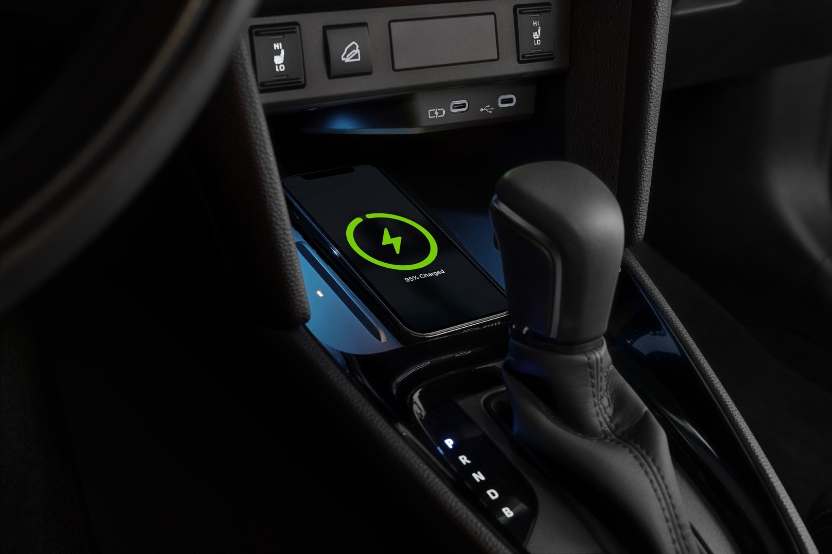 Detalle del cargador inalámbrico y la palanca de cambios.