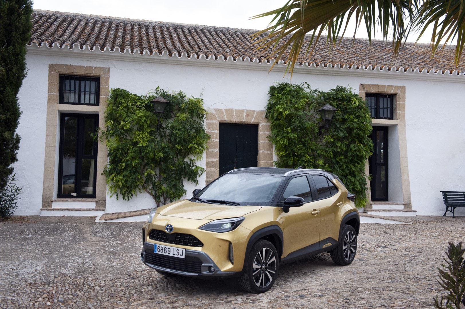 Toyota Yaris Cross híbrido mostrando su diseño frontal y lateral en un entorno rústico.