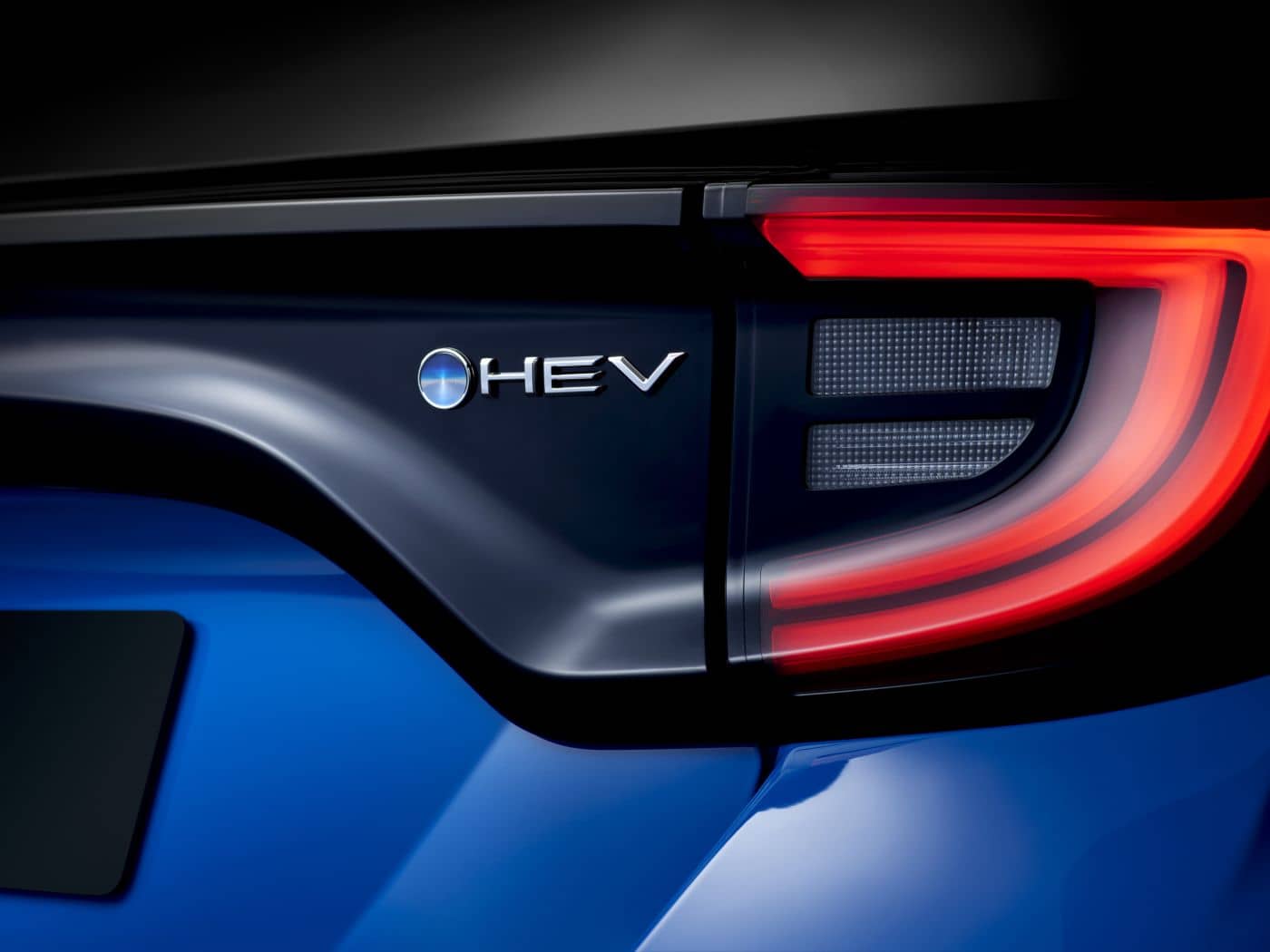 Detalle denotando la tecnología híbrida a través de la insignia y las luces traseras.
