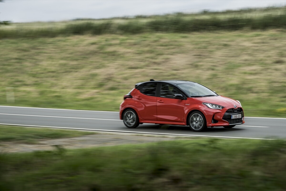 Imagen lateral del Toyota Yaris en movimiento cerca de un campo. Imagen lateral del Toyota Yaris en movimiento cerca de un campo.