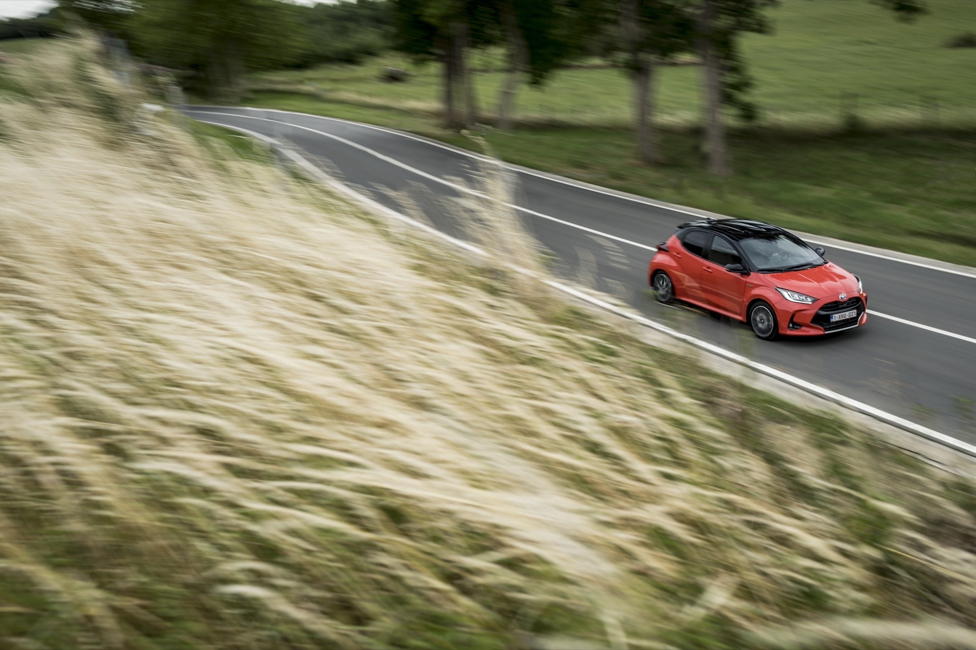 Yaris en acción en carretera rural, vinculando diseño con entorno natural.