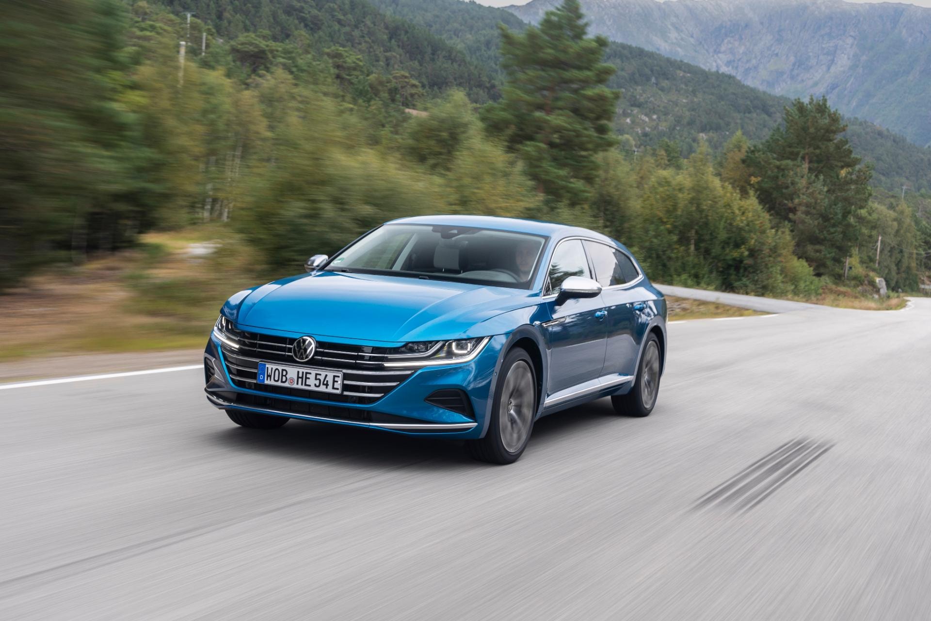 Volkswagen Arteon híbrido capturado en acción, mostrando su frente y lado en azul metálico.