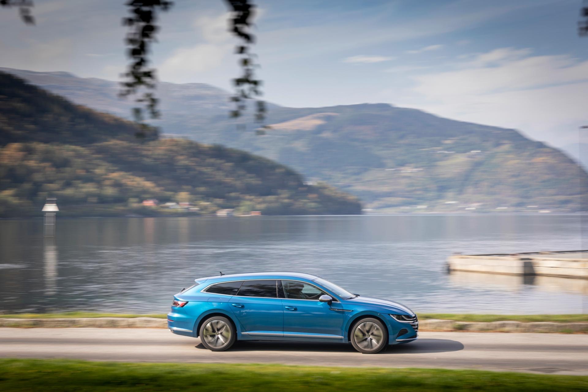 Vista dinámica del Volkswagen Arteon Híbrido deslizándose por una carretera costera.
