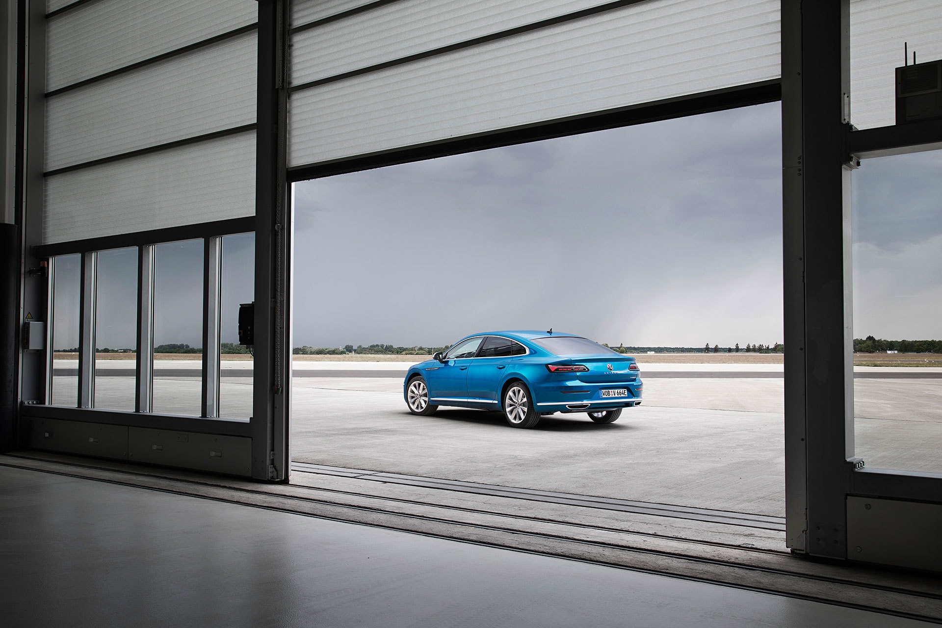 Volkswagen Arteon azul visto a distancia, enfocando trasera y techo.