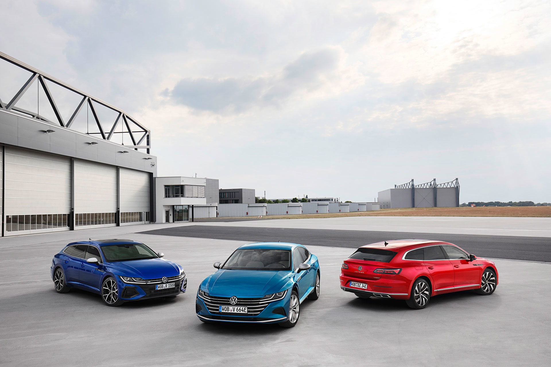 Tres Volkswagen Arteon en distintos colores frente a un hangar.