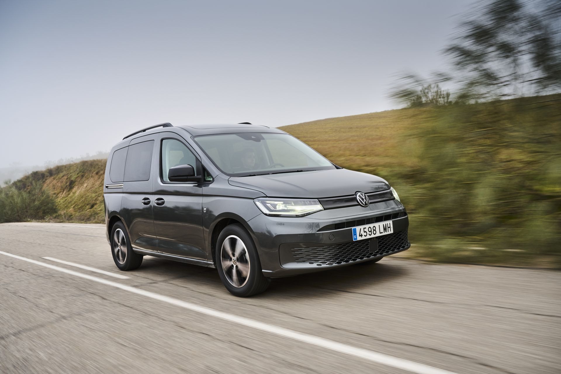 El Volkswagen Caddy en una carretera, vista lateral resaltando su perfil.