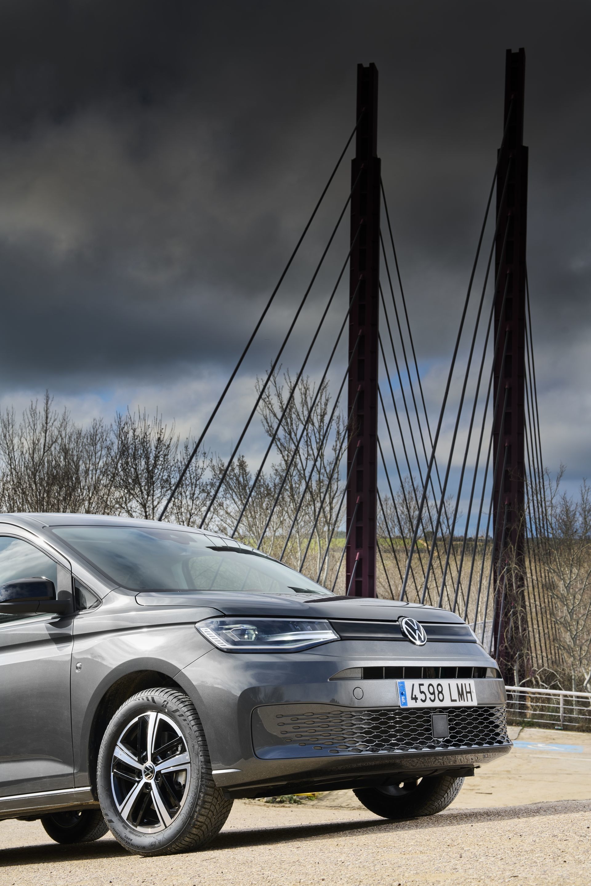 Estampa imponente del Volkswagen Caddy delante de una estructura moderna, vista delantera.