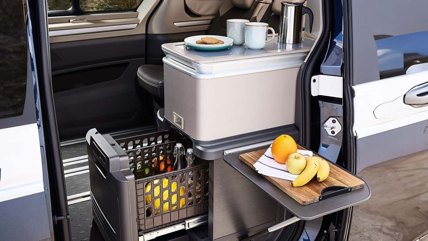 Cocina integrada en Volkswagen California con frigorífico y almacenaje.