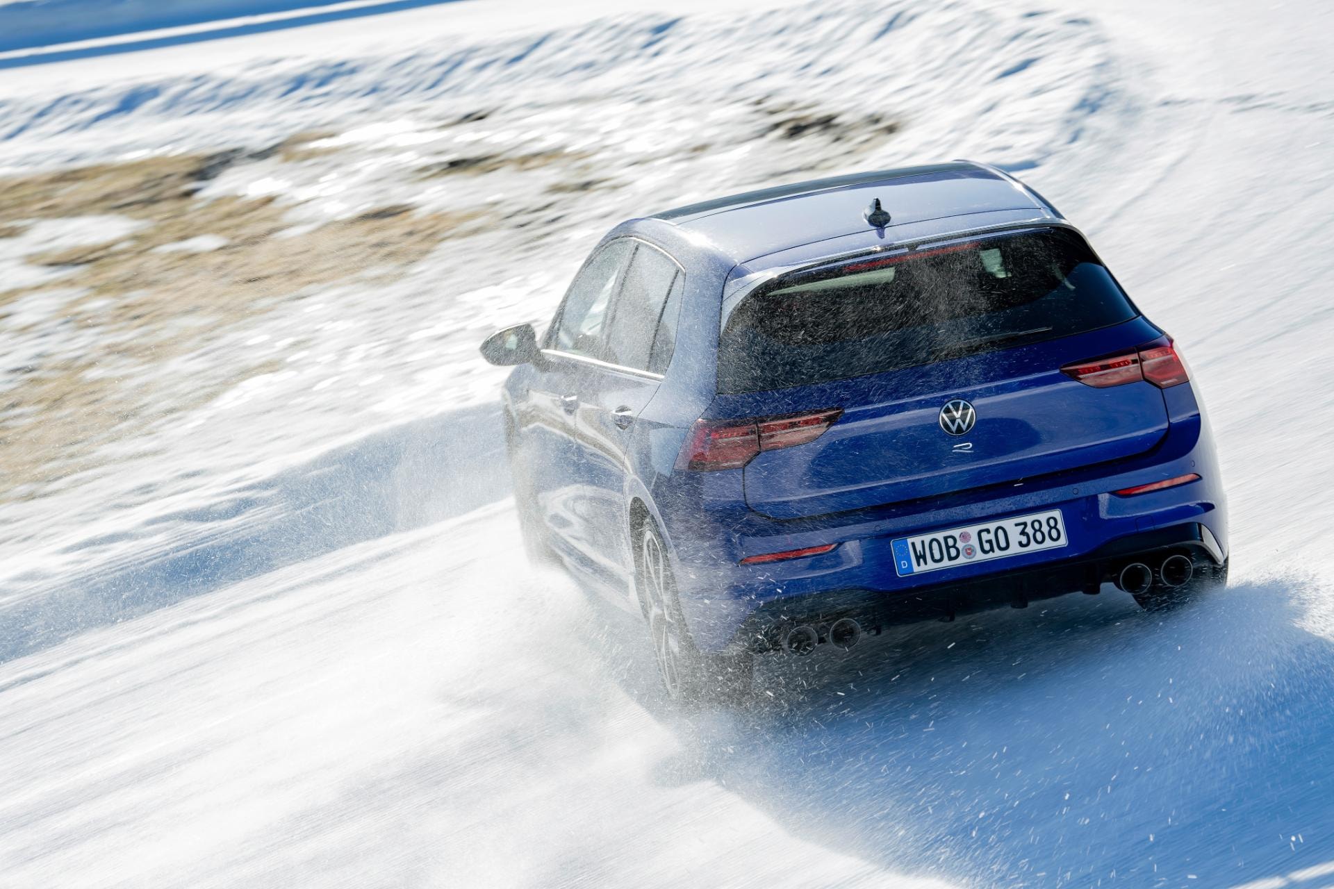 Golf R en acción, controlando un derrape en superficie nevada.