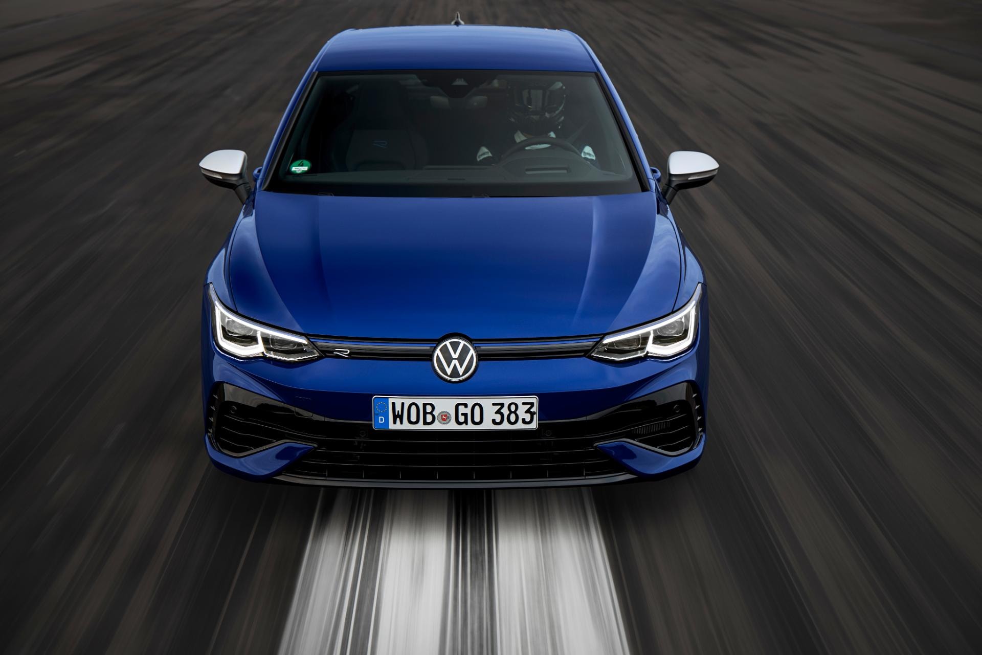 Volkswagen Golf R capturado de frente con efecto de velocidad en la carretera.