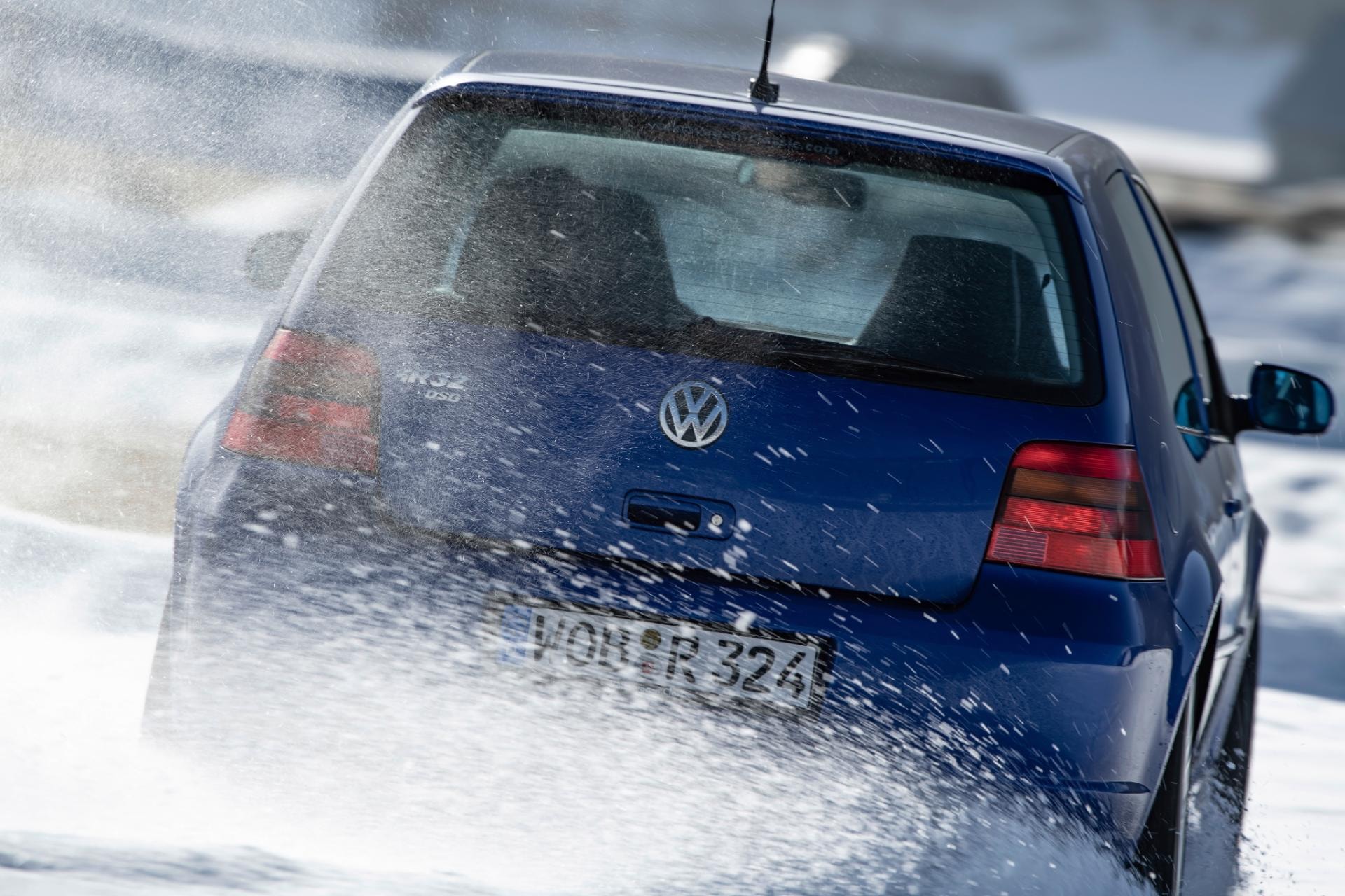 Imagen dinámica de la parte trasera del Volkswagen Golf R, destacando la potencia y tracción sobre nieve.