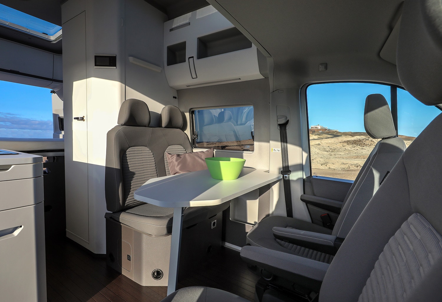 Interior del Grand California con enfoque en la zona de asientos y comedor.