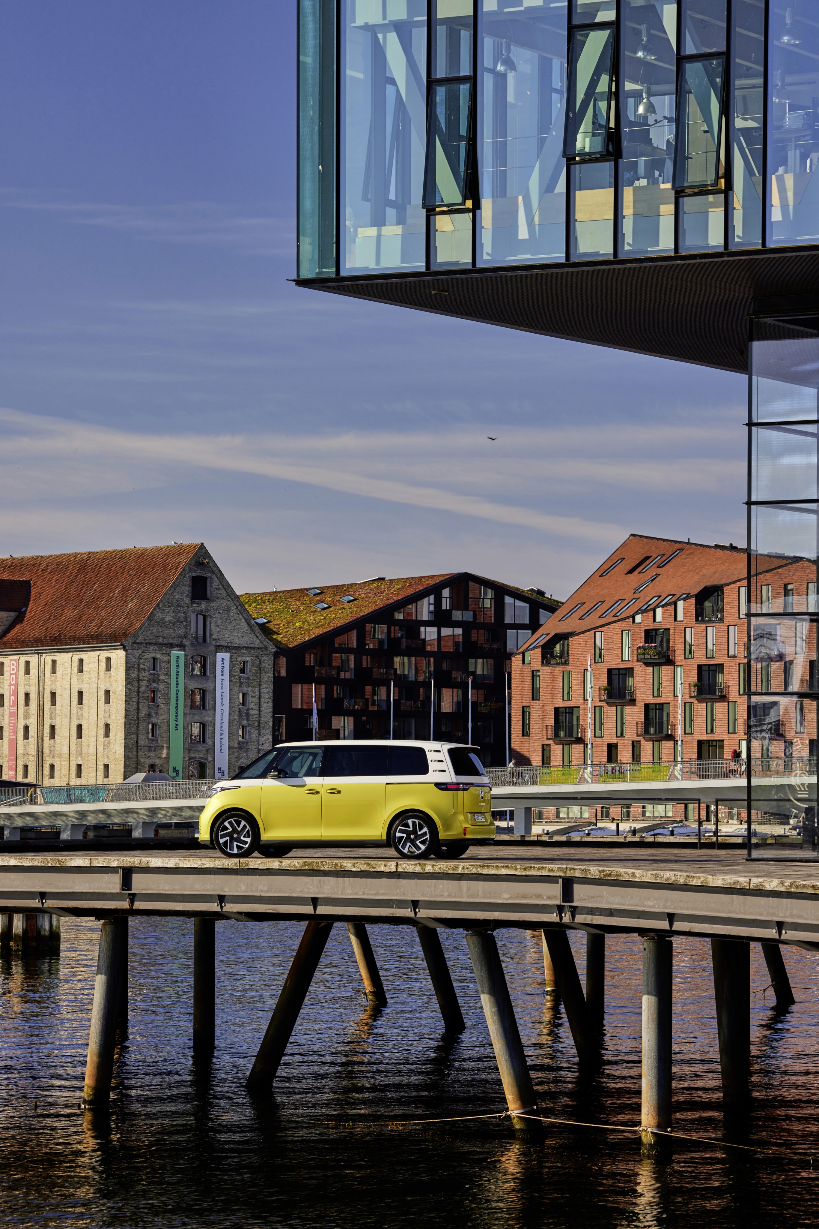 Volkswagen ID. Buzz aparcado en un paisaje urbano moderno.