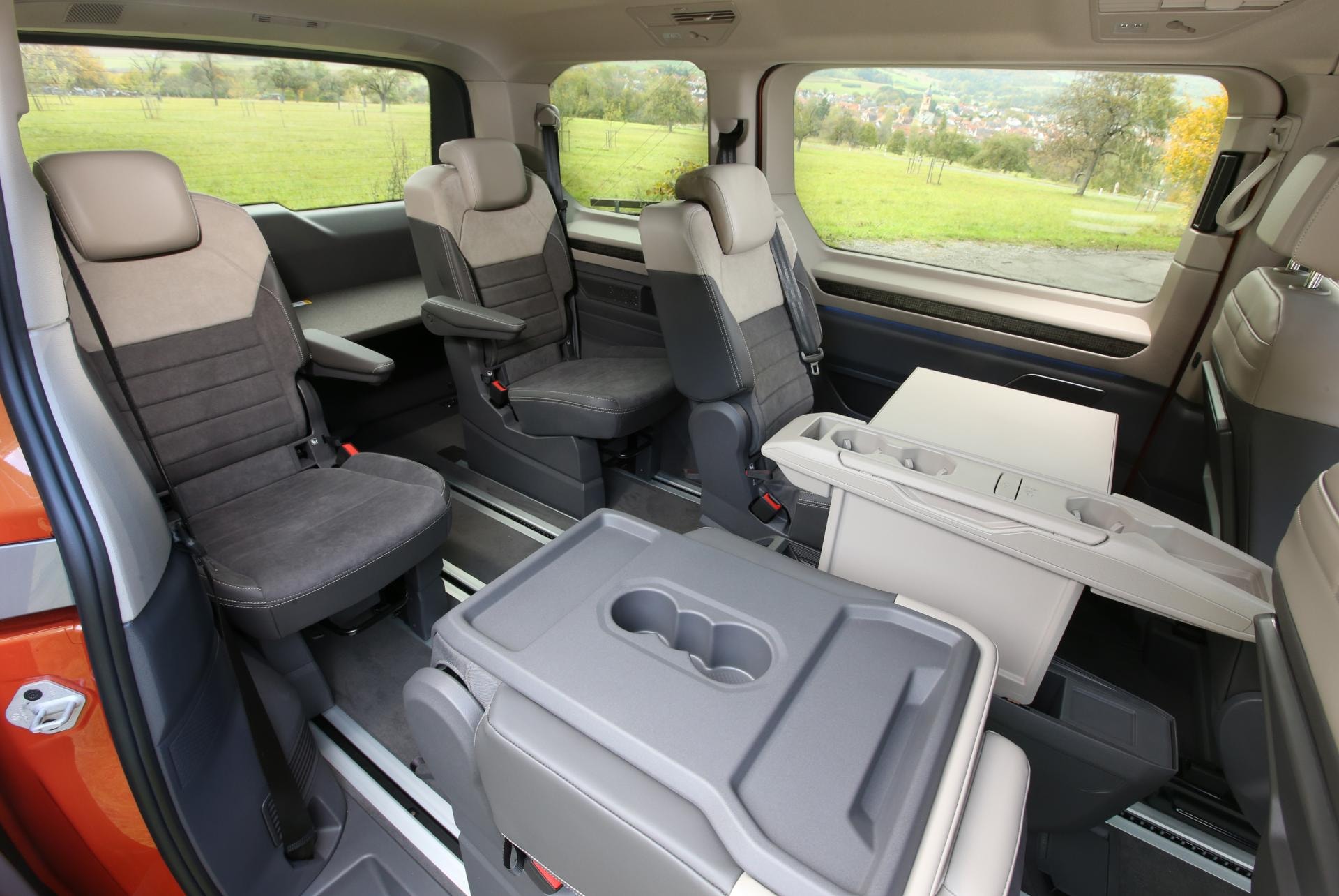 Interior mostrando asientos y mesita desplegable en detalle