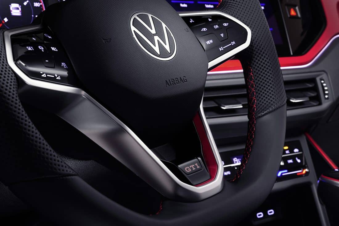 Detalle del volante deportivo con emblema GTI y controles integrados.