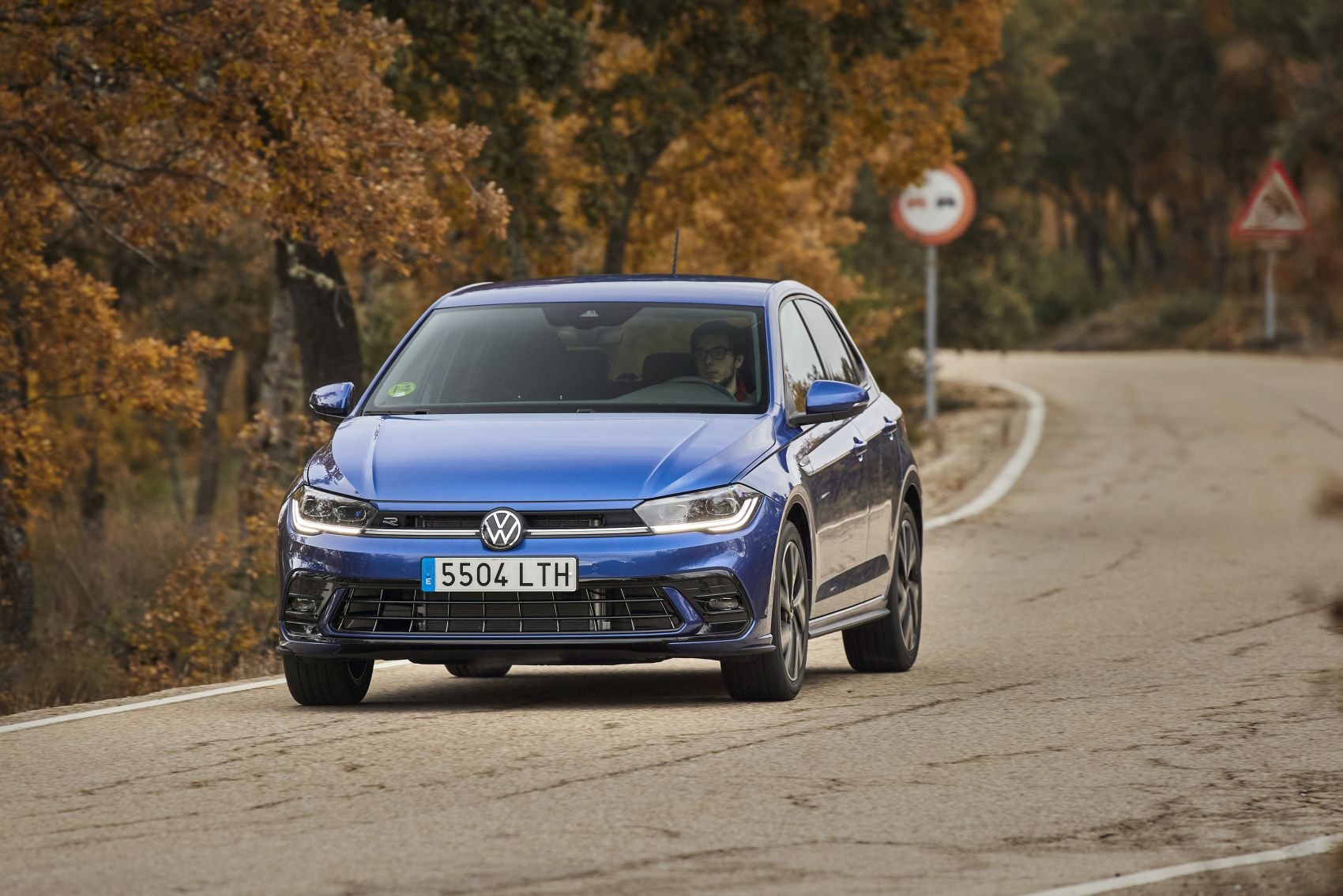 Polo azul tomando una curva, mostrando su maniobrabilidad en carreteras.