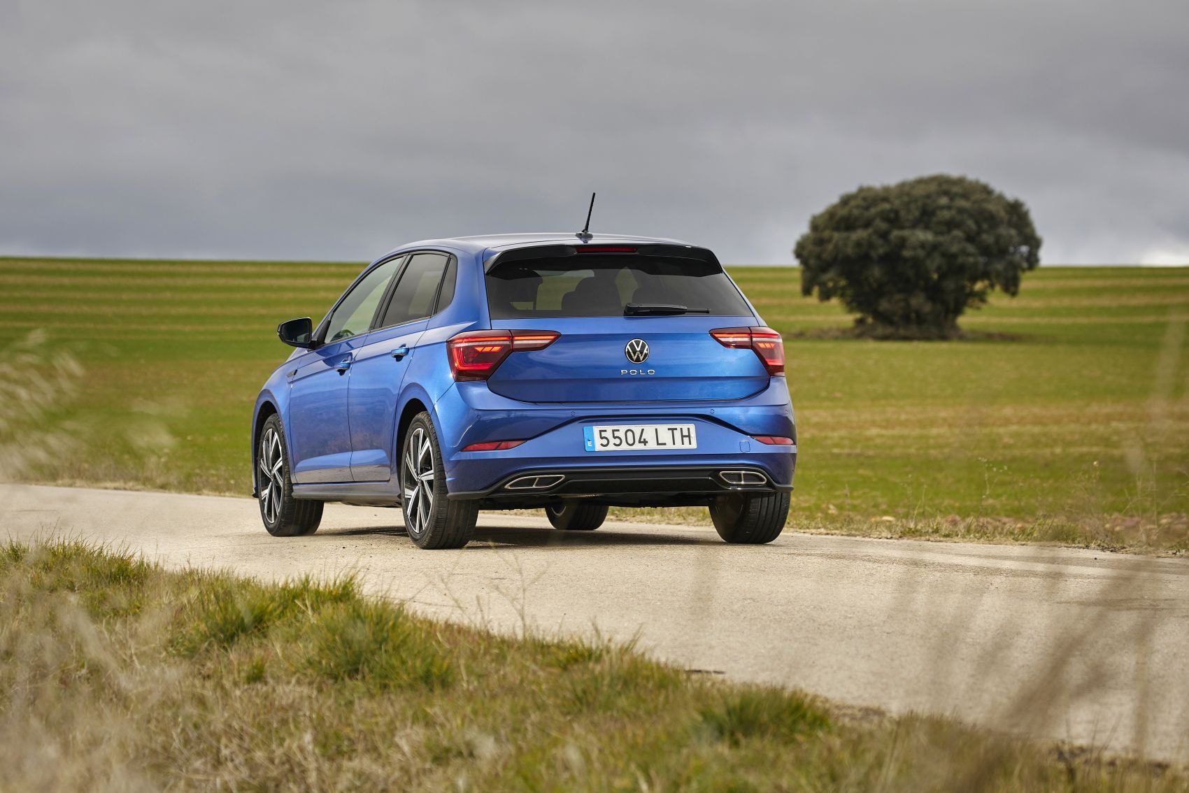 Volkswagen Polo azul en un entorno rural, representando aventura.