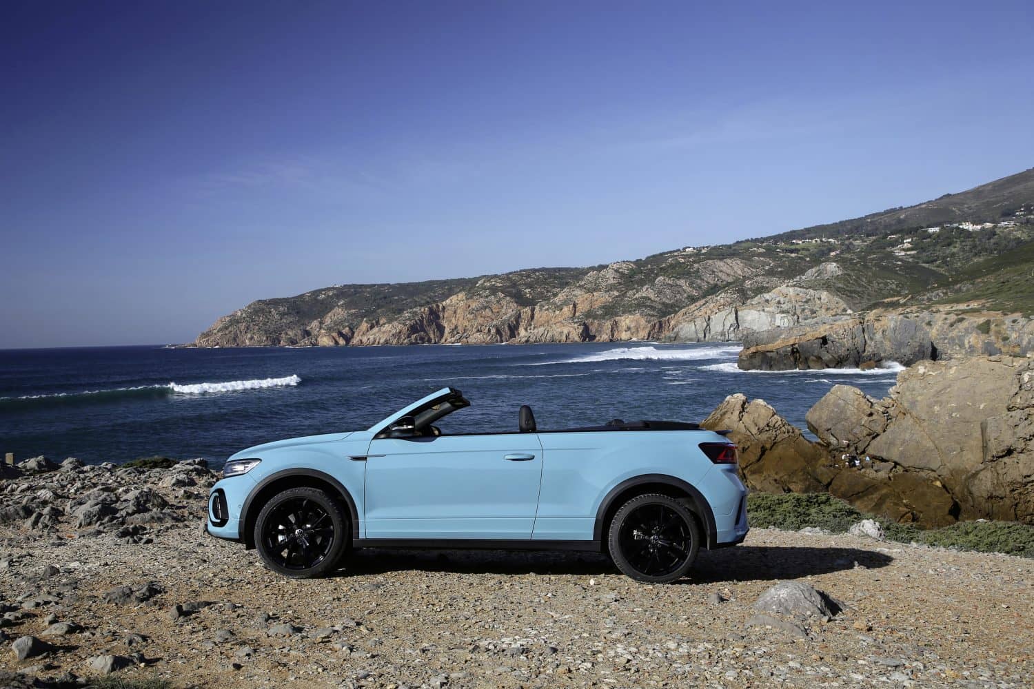 Volkswagen T-Roc Cabrio azul, perfilando costa mediterránea.